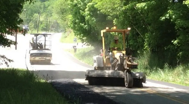 A Shallenberger grader and roller working a graded surface